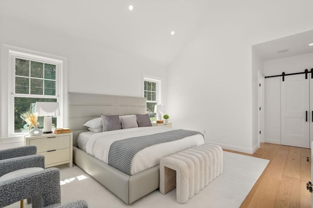 1 Cole Rd, Wayland, MA 01778 - bedroom featuring multiple windows, a barn door, light wood-style flooring, recessed lighting, and vaulted ceiling