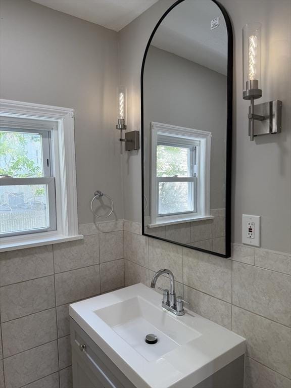 28 Foster St, Brockton, MA 02301 - bathroom with tile walls, plenty of natural light, vanity, and wainscoting