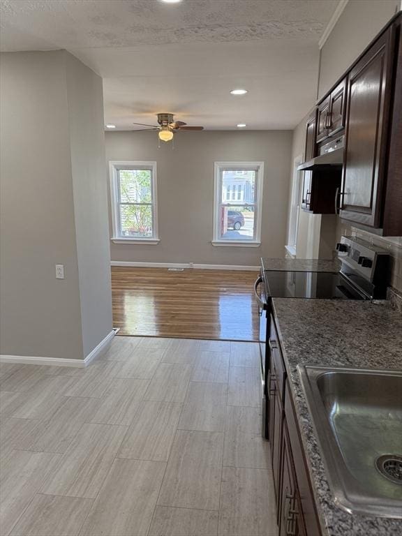 28 Foster St, Brockton, MA 02301 - kitchen with appliances with stainless steel finishes, dark brown cabinetry, light wood-style flooring, baseboards, and a sink
