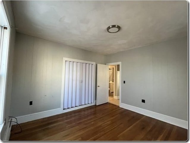 unfurnished bedroom with dark wood-type flooring