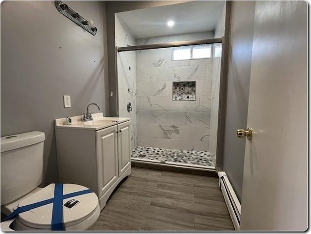 bathroom featuring a baseboard radiator, vanity, an enclosed shower, and hardwood / wood-style floors