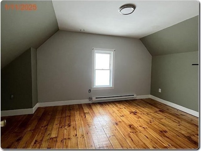 bonus room with baseboard heating, vaulted ceiling, and light wood-type flooring