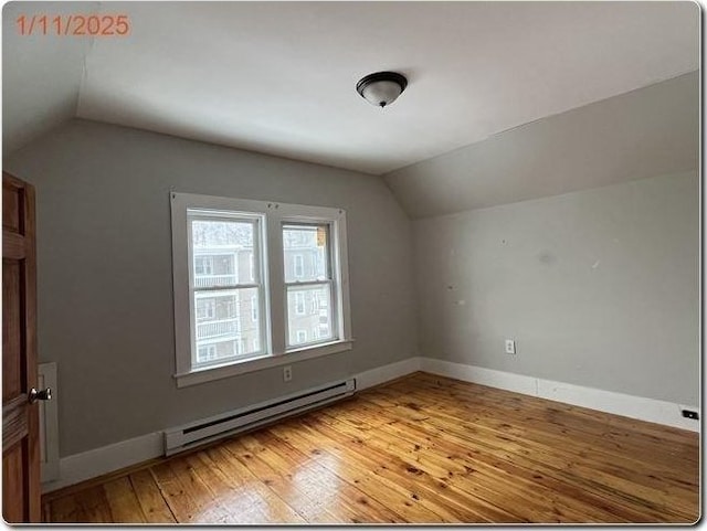 bonus room featuring baseboard heating, wood-type flooring, and vaulted ceiling