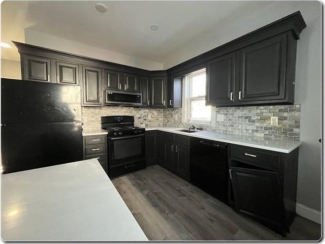 kitchen featuring tasteful backsplash, dark hardwood / wood-style floors, and black appliances