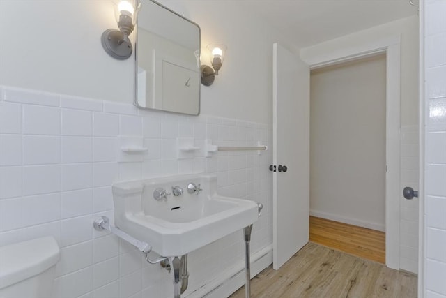 bathroom with tile walls, hardwood / wood-style flooring, and toilet