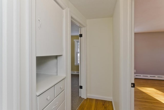 hallway with hardwood / wood-style floors and baseboard heating