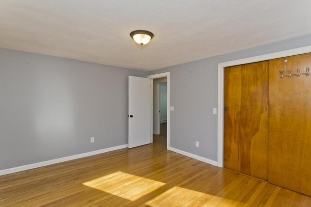 unfurnished bedroom featuring hardwood / wood-style floors and a closet