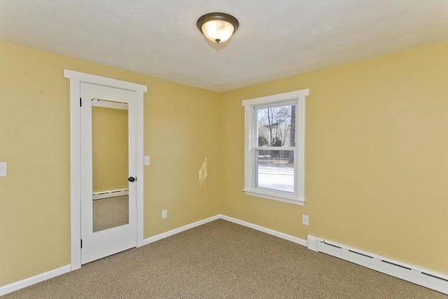 carpeted empty room featuring a baseboard heating unit