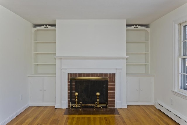 unfurnished living room featuring hardwood / wood-style flooring, a baseboard heating unit, and a fireplace