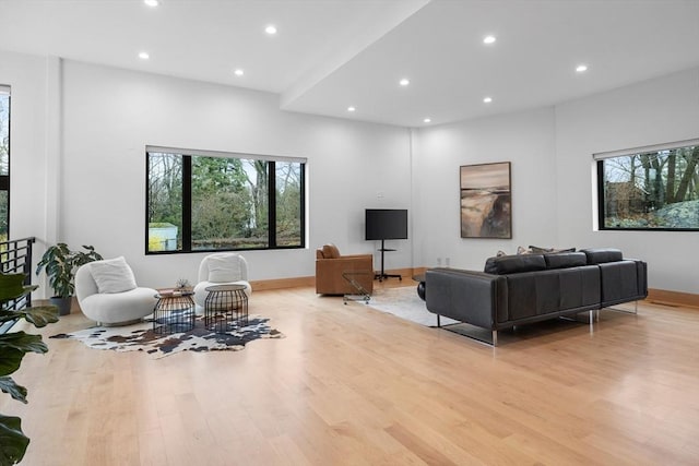 living area with light wood finished floors, healthy amount of natural light, recessed lighting, and baseboards