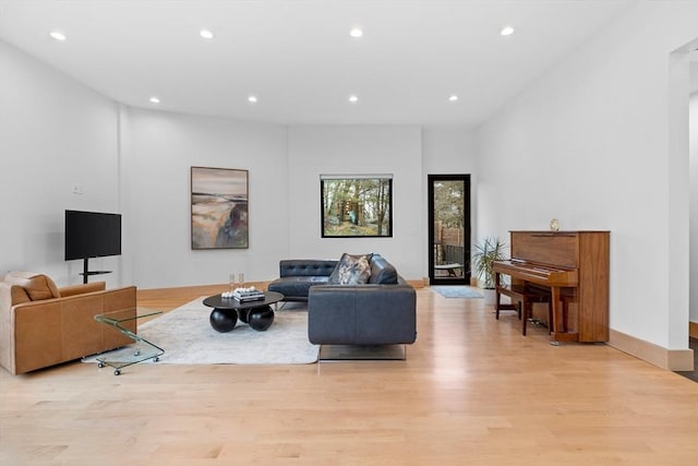 living room with light wood finished floors, recessed lighting, and baseboards