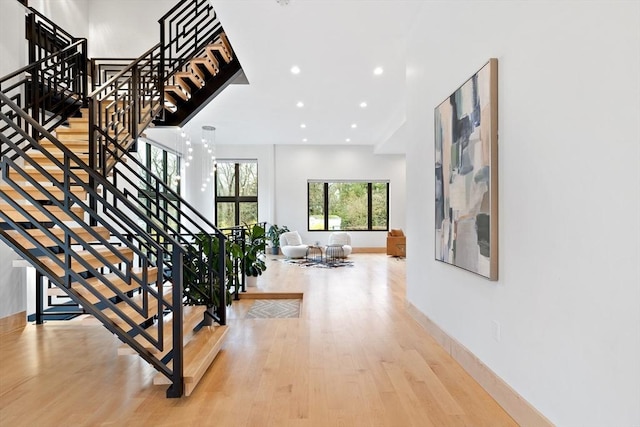 stairs featuring wood finished floors, baseboards, and recessed lighting