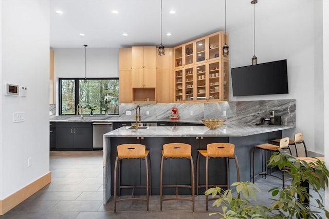 kitchen featuring stainless steel dishwasher, tasteful backsplash, light stone counters, and recessed lighting