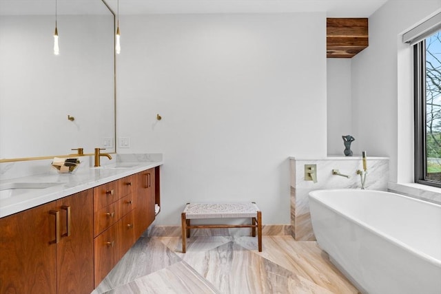 full bathroom with healthy amount of natural light, a soaking tub, and double vanity