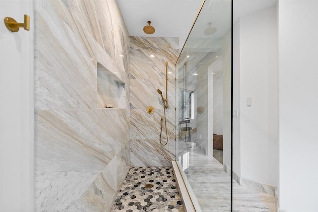 bathroom featuring a marble finish shower