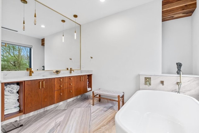 bathroom featuring a freestanding tub, double vanity, and recessed lighting