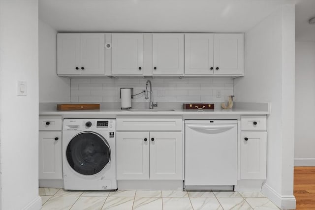 clothes washing area featuring washer / clothes dryer and baseboards