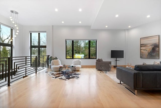 living room with plenty of natural light, recessed lighting, wood finished floors, and baseboards
