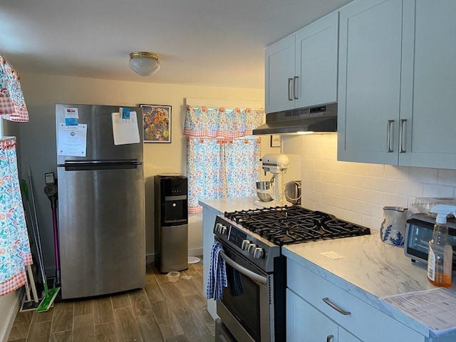 kitchen featuring appliances with stainless steel finishes, dark hardwood / wood-style flooring, and backsplash