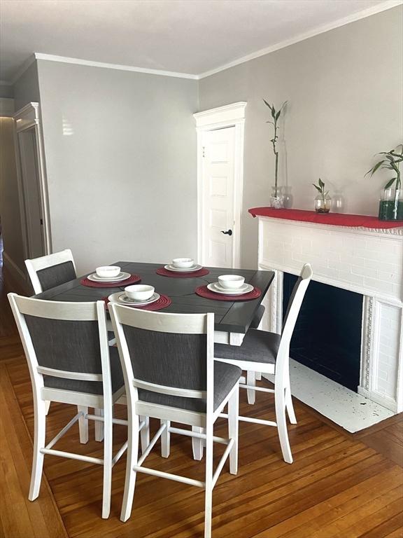 dining room with ornamental molding and wood finished floors