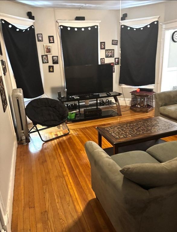 living room with wood finished floors and radiator