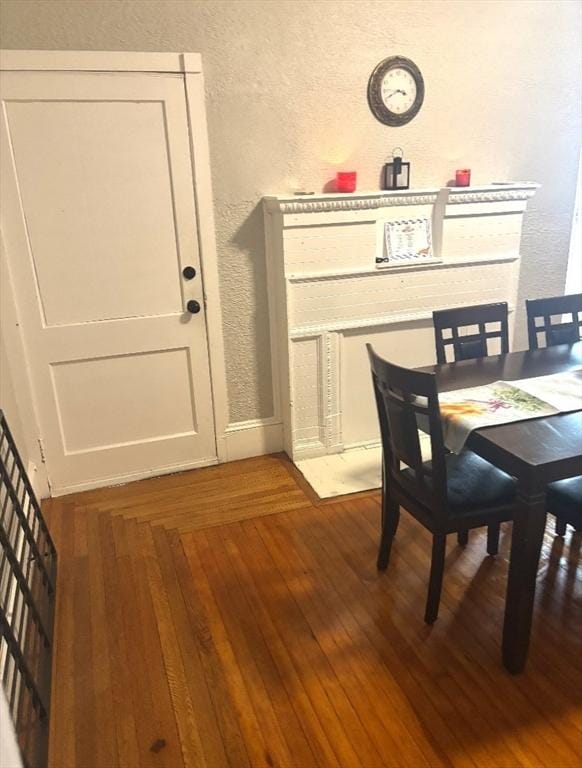 dining space featuring dark wood-style floors and a textured wall