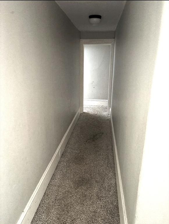 corridor featuring carpet flooring and baseboards