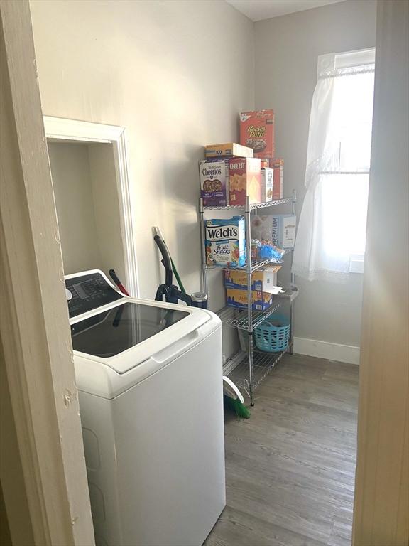 washroom with laundry area, washer / clothes dryer, wood finished floors, and a healthy amount of sunlight