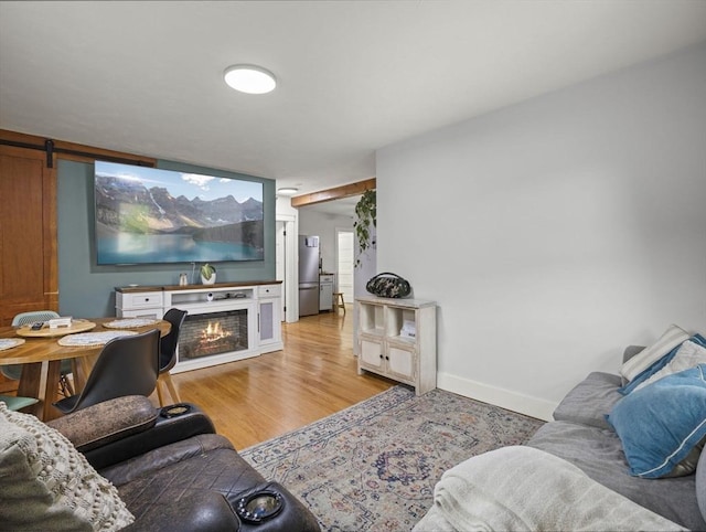 4 Darling St, Worcester, MA 01605 - living room featuring light wood finished floors, a lit fireplace, baseboards, and a barn door