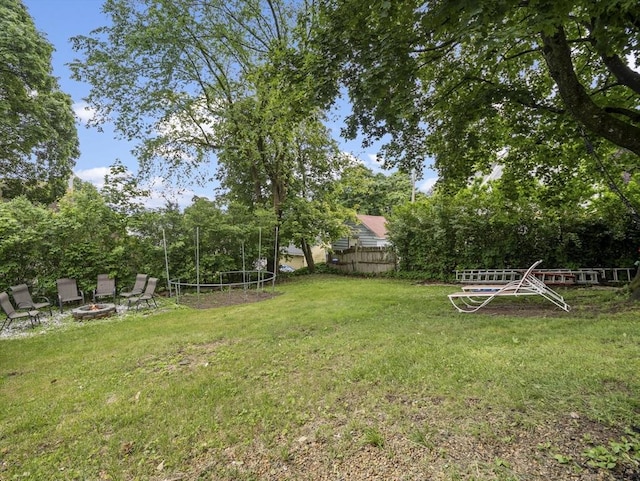 4 Darling St, Worcester, MA 01605 - view of yard with a trampoline, a fire pit, and view of wooded area