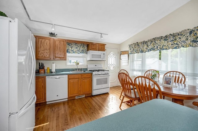 33 Hopkins St, Dracut, MA 01826 - kitchen featuring white appliances, rail lighting, light wood finished floors, brown cabinetry, and vaulted ceiling