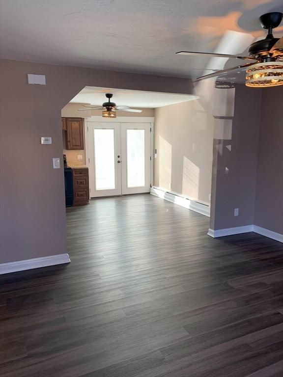 unfurnished living room with ceiling fan, french doors, and dark hardwood / wood-style floors