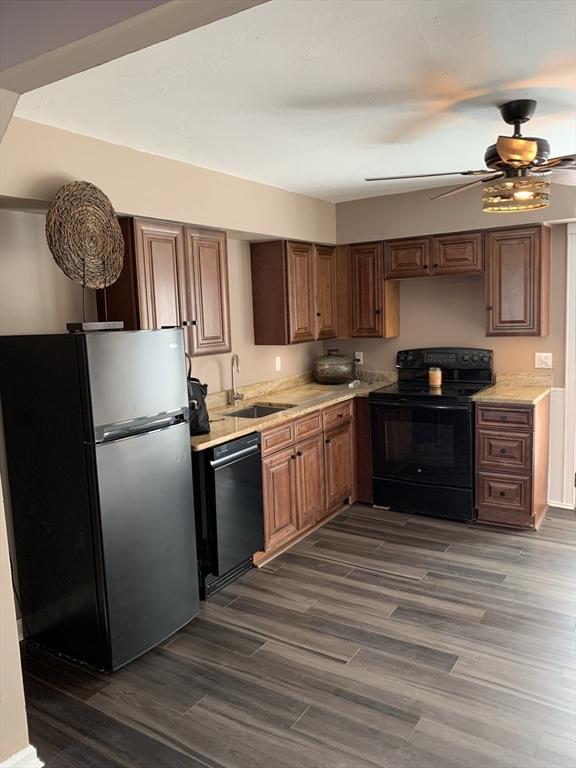 kitchen featuring black appliances, dark hardwood / wood-style floors, ceiling fan, and sink