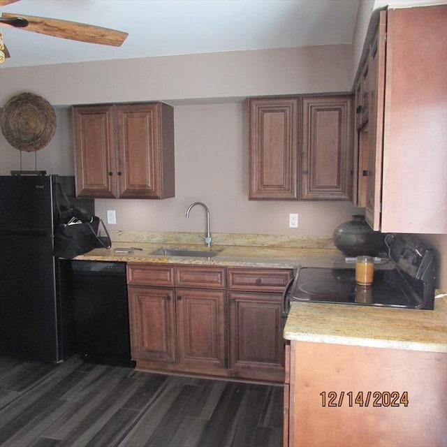 kitchen featuring ceiling fan, sink, light stone counters, dark hardwood / wood-style flooring, and black appliances