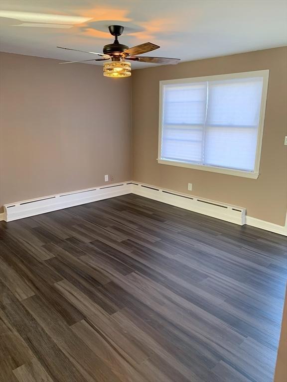 unfurnished room featuring ceiling fan and dark wood-type flooring