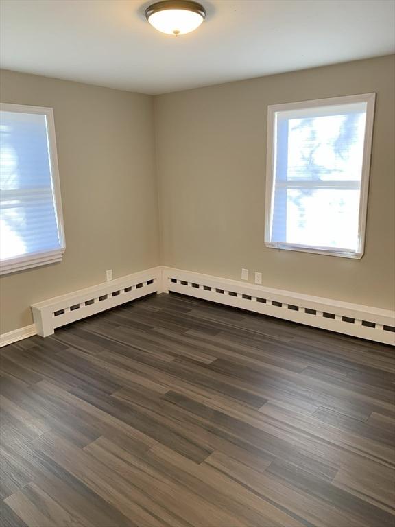 unfurnished room with dark wood-type flooring