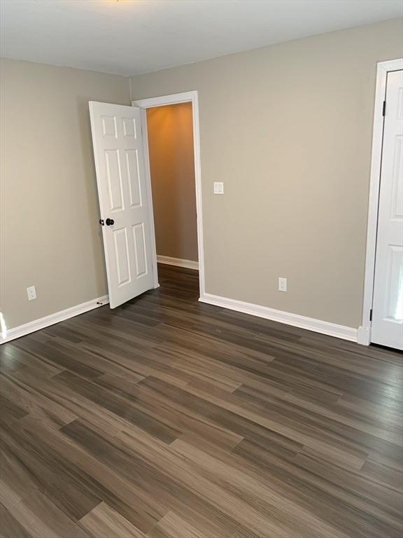 empty room with dark hardwood / wood-style floors