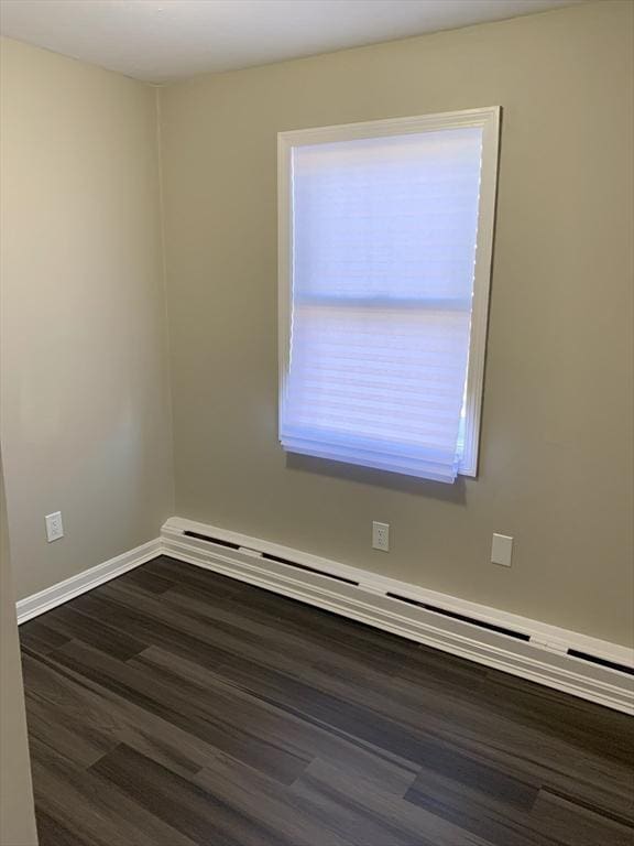 spare room featuring dark hardwood / wood-style floors and a baseboard radiator