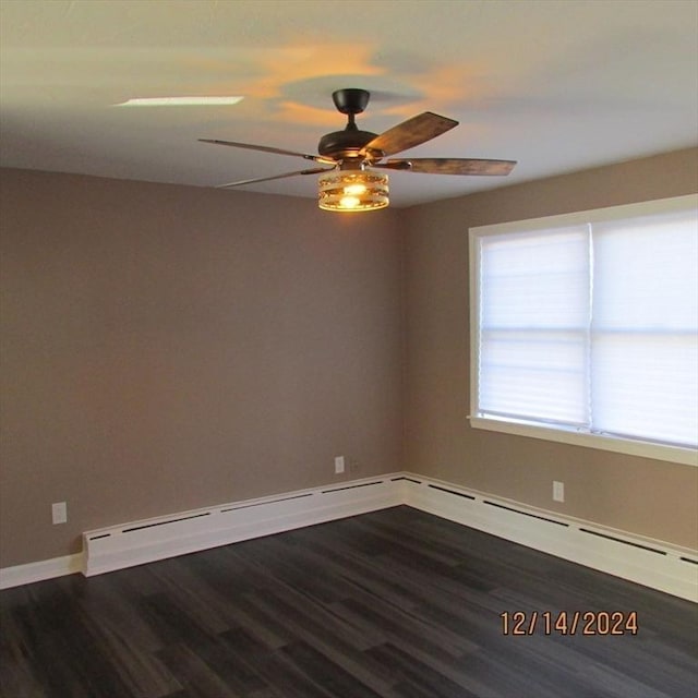 spare room with baseboard heating, dark wood-type flooring, and ceiling fan