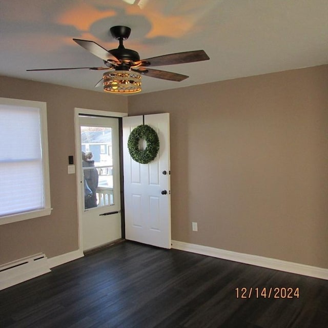 foyer with ceiling fan, dark wood-type flooring, and a baseboard heating unit