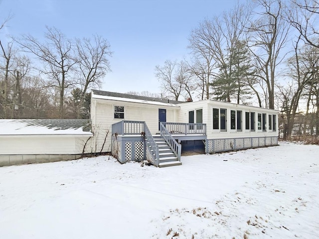 snow covered property with a deck