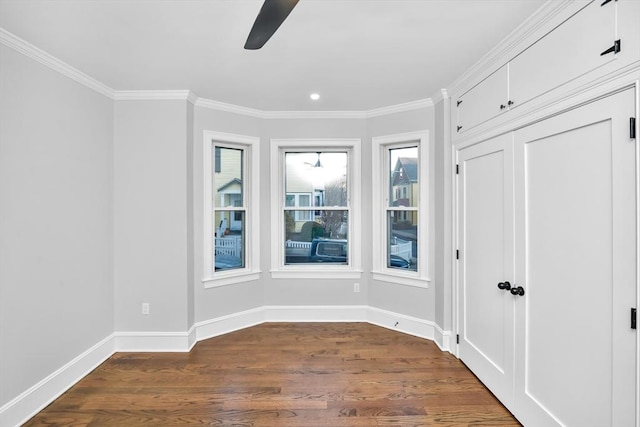 spare room with dark hardwood / wood-style flooring, ceiling fan, and ornamental molding