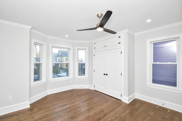 unfurnished bedroom with a closet, ceiling fan, crown molding, and dark hardwood / wood-style floors