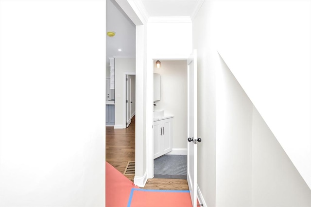 corridor featuring hardwood / wood-style flooring and ornamental molding