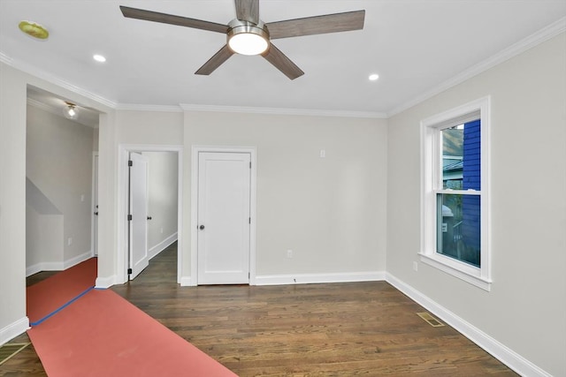 unfurnished room with crown molding, ceiling fan, and dark wood-type flooring