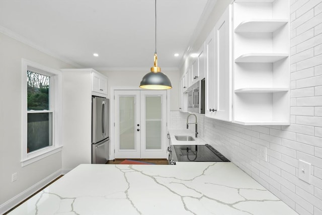 kitchen featuring light stone counters, ornamental molding, stainless steel appliances, white cabinetry, and hanging light fixtures