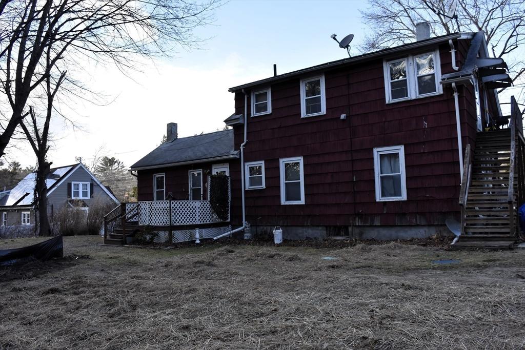 rear view of house with stairway and a chimney