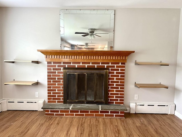 15 Evans, Somerset, MA 02726 - detailed view of a ceiling fan, a baseboard radiator, wood finished floors, and a brick fireplace