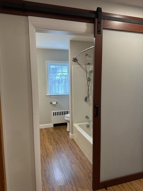 15 Evans, Somerset, MA 02726 - bathroom with radiator heating unit, wood finished floors, and washtub / shower combination