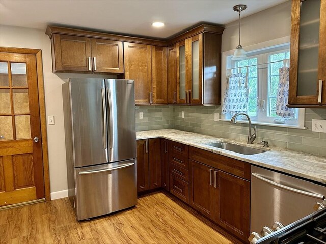 15 Evans, Somerset, MA 02726 - kitchen featuring appliances with stainless steel finishes, light wood-style floors, tasteful backsplash, decorative light fixtures, and glass insert cabinets